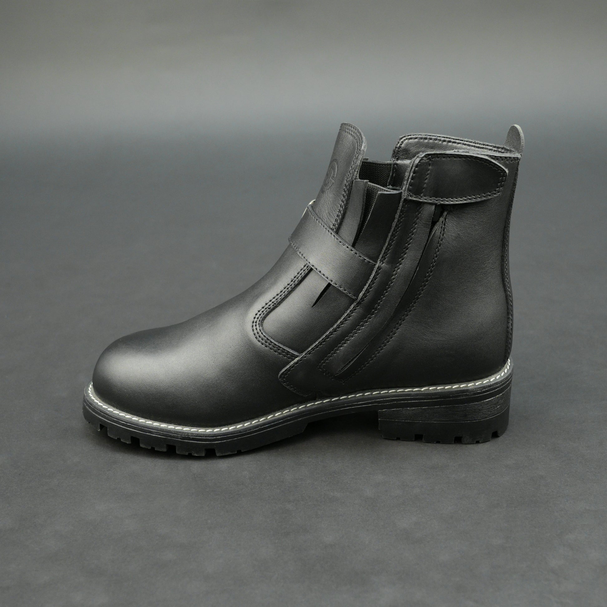 Matte black bovine leather biker boots with side buckle and zipper.