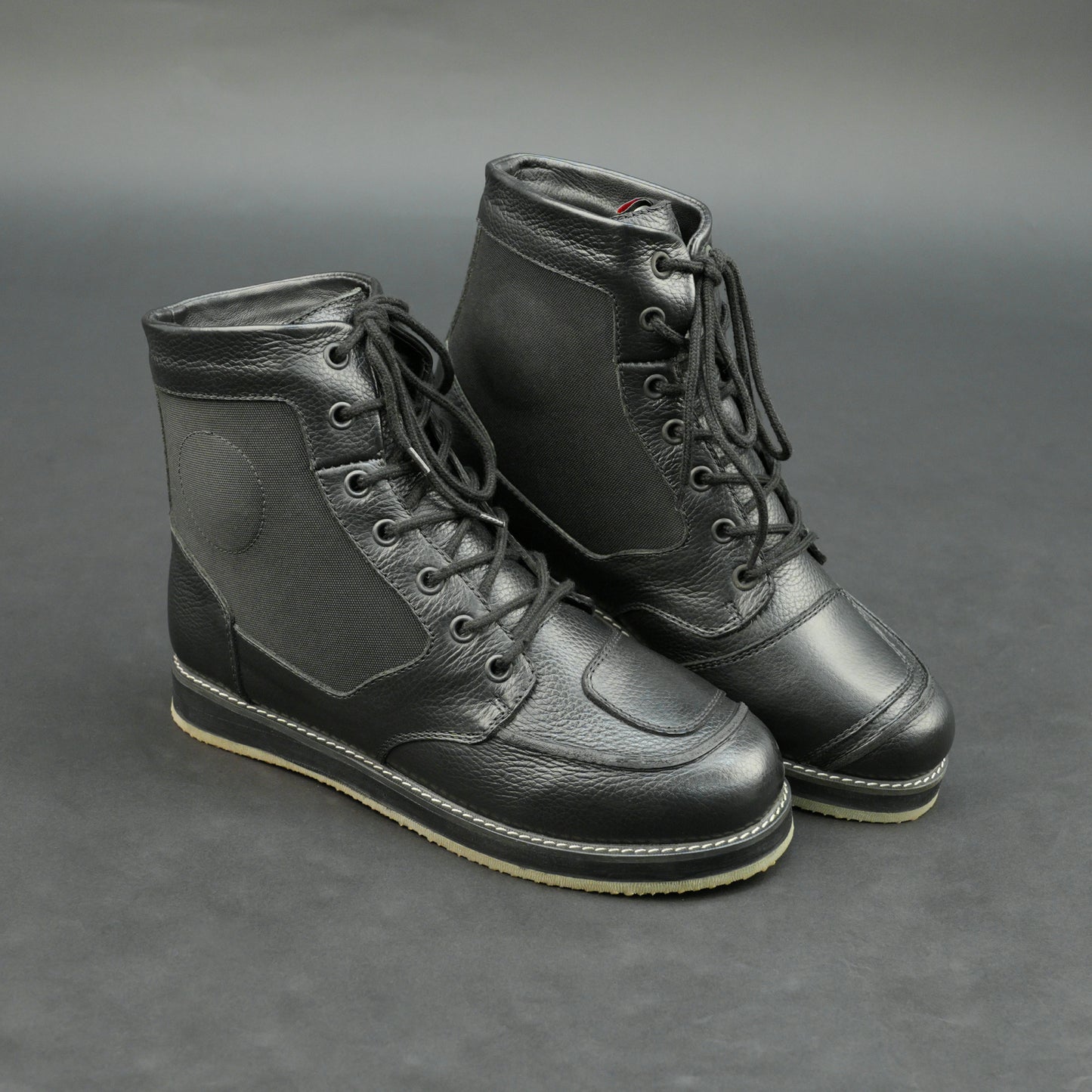 Black high-ankle motorbike boots with mesh panels.