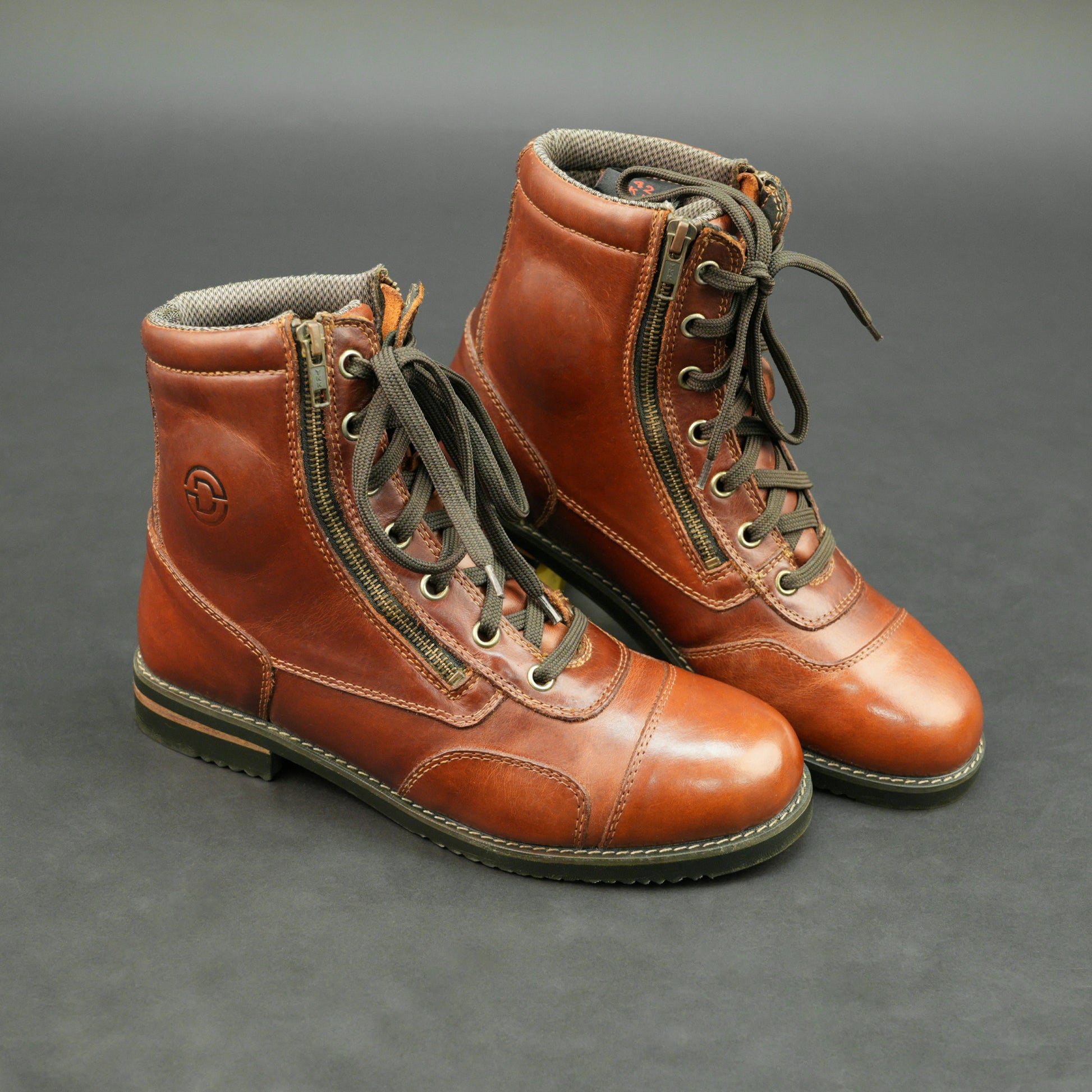 Cognac brown bovine leather motorbike boots with side zipper and lace-up design.