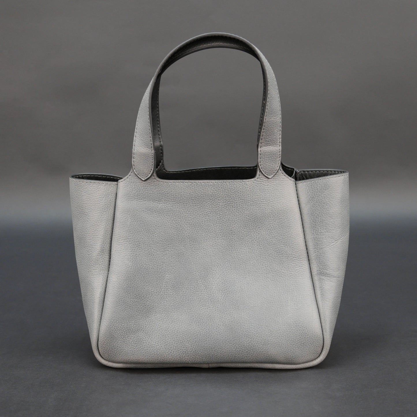 Premium grey cow vachetta leather bag with spacious compartment and inner pockets.
