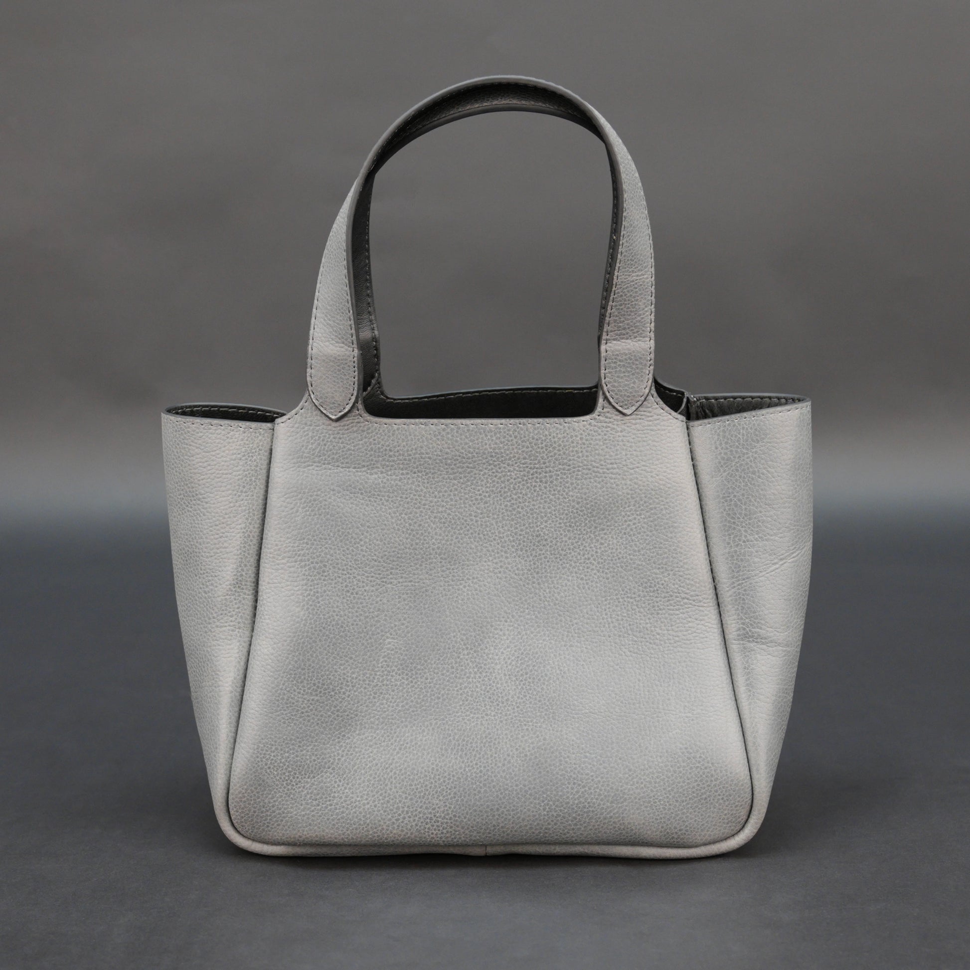 Premium grey cow vachetta leather bag with spacious compartment and inner pockets.