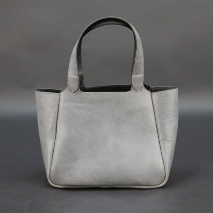 Premium grey cow vachetta leather bag with spacious compartment and inner pockets.