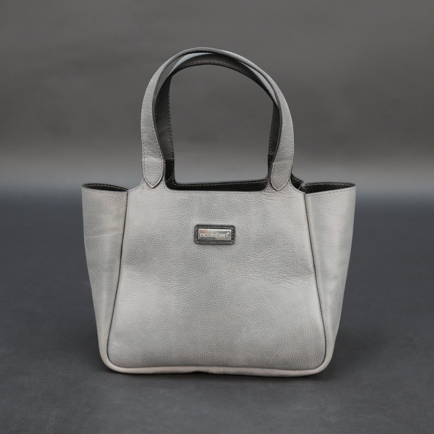 Premium grey cow vachetta leather bag with spacious compartment and inner pockets.