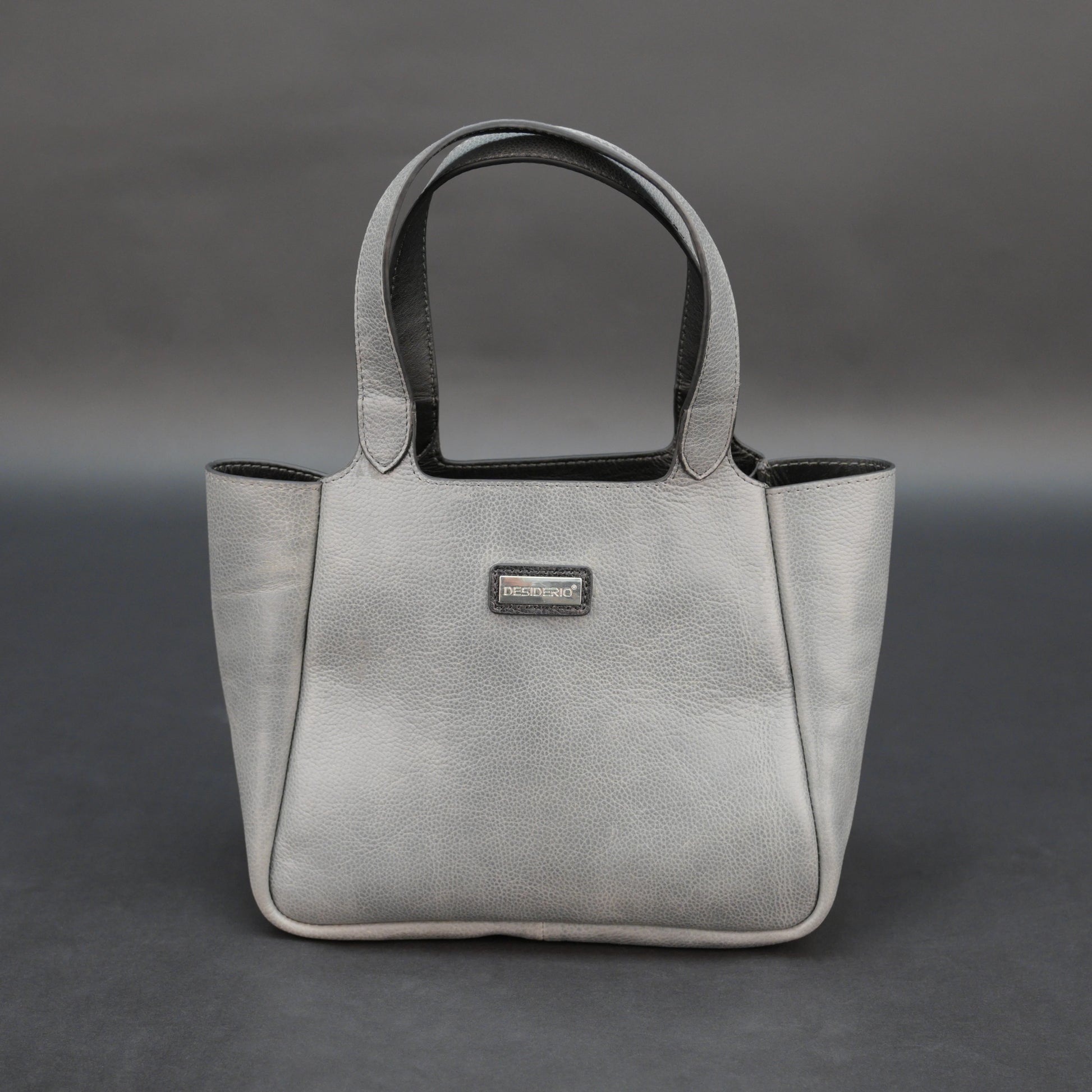 Premium grey cow vachetta leather bag with spacious compartment and inner pockets.