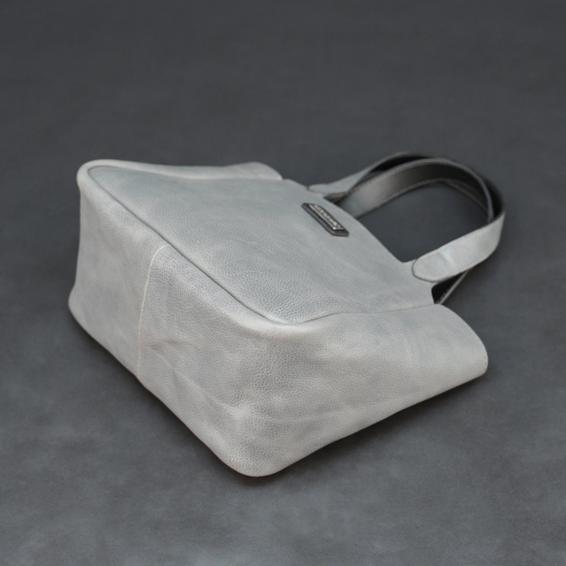 Premium grey cow vachetta leather bag with spacious compartment and inner pockets.