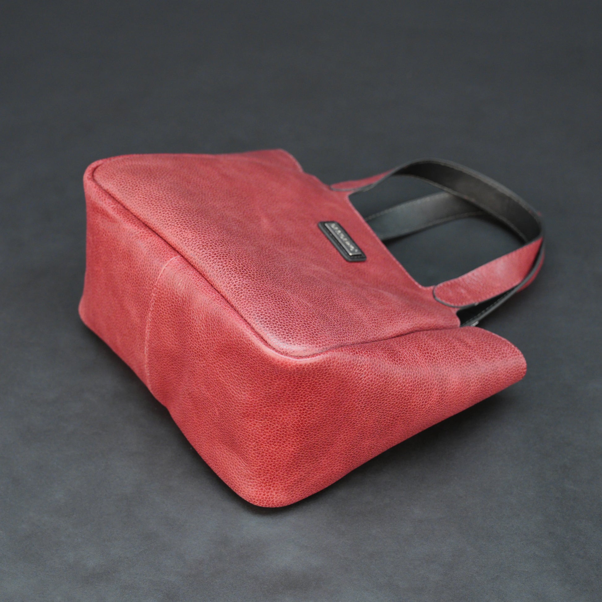 Premium red cow vachetta leather bag with spacious compartment and inner pockets.