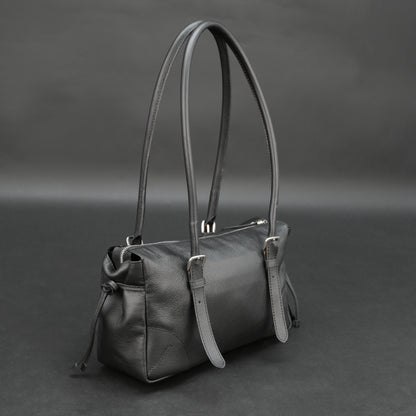 Black cow Chelsea leather bag with strap and pockets.