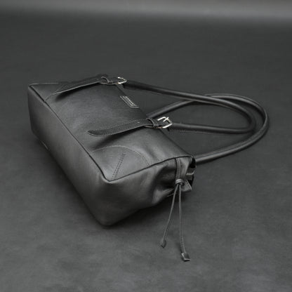 Black cow Chelsea leather bag with strap and pockets.