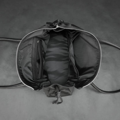 Black cow Chelsea leather bag with strap and pockets.