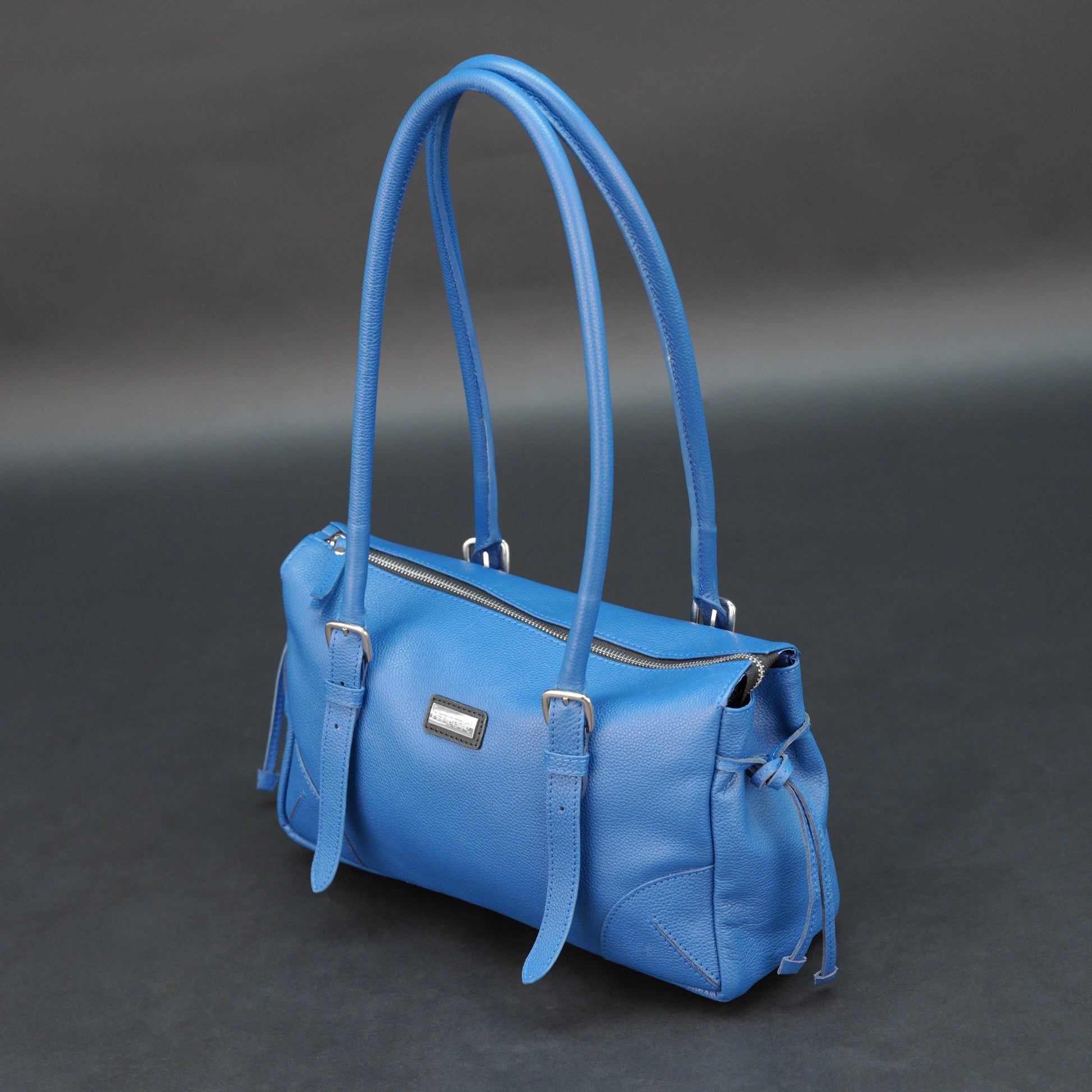 Blue cow PDM leather bag with shoulder strap and pockets.