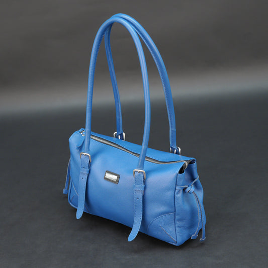 Blue cow PDM leather bag with shoulder strap and pockets.
