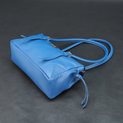 Blue cow PDM leather bag with shoulder strap and pockets.