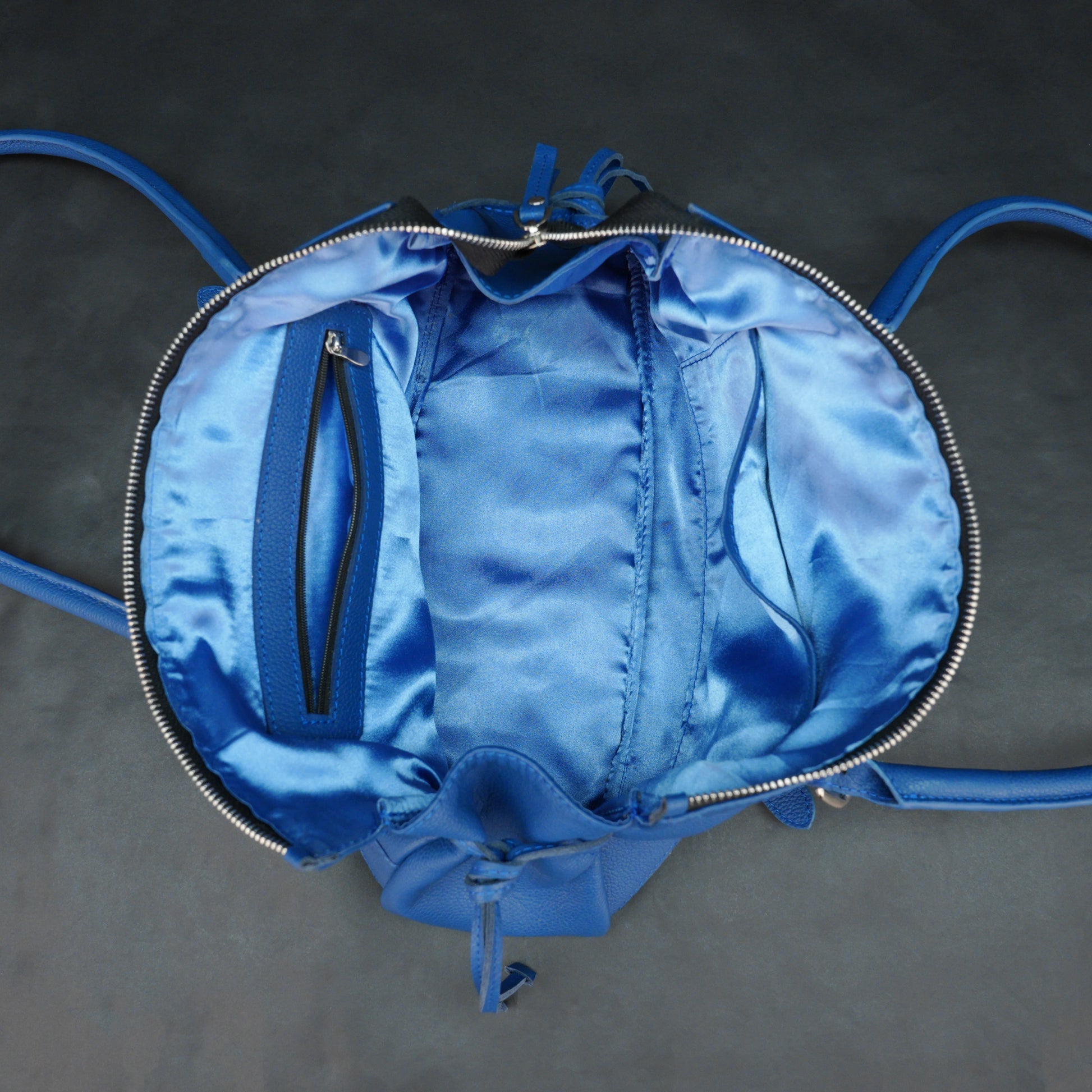 Blue cow PDM leather bag with shoulder strap and pockets.