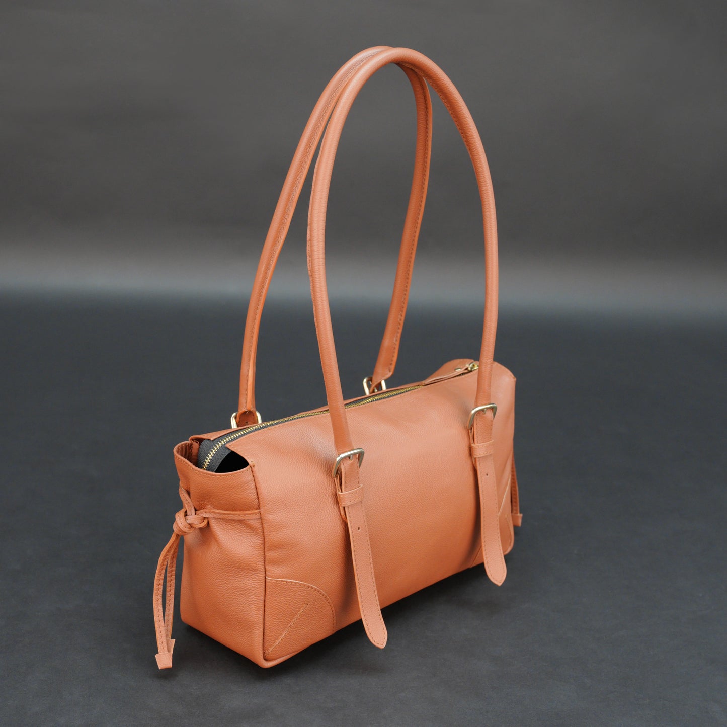 Tan cow Chelsea leather bag with shoulder strap, main compartment, and inner pockets.
