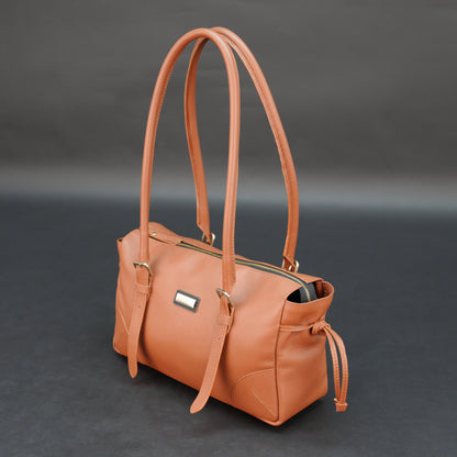 Tan cow Chelsea leather bag with shoulder strap, main compartment, and inner pockets.