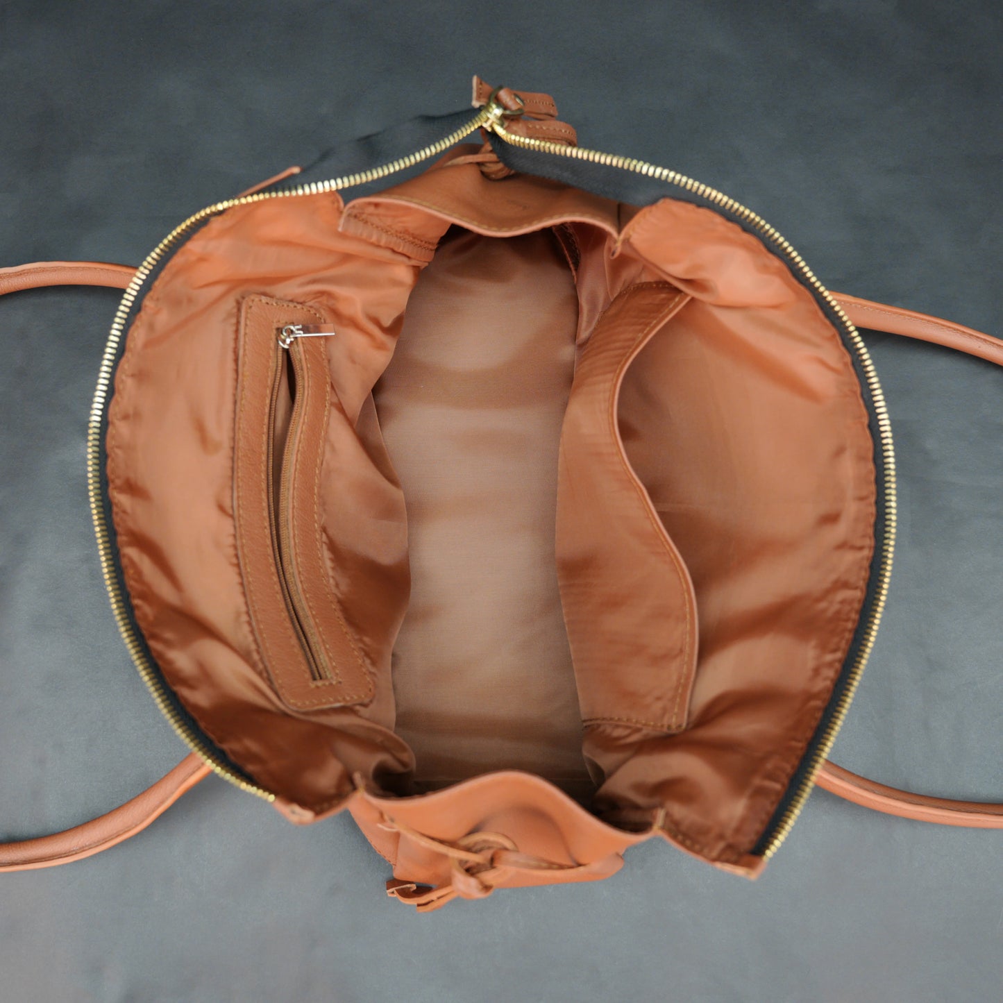 Tan cow Chelsea leather bag with shoulder strap, main compartment, and inner pockets.