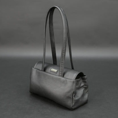 Black cow Chelsea leather bag with straps, compartments, and zipper pocket.
