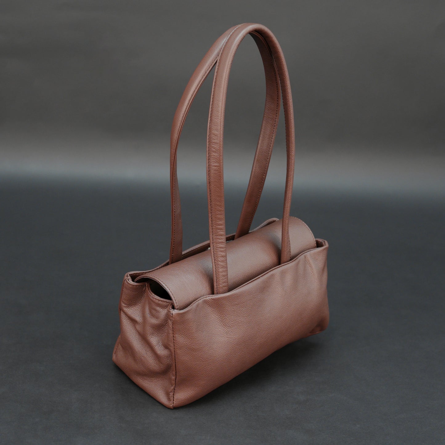Brown cow Chelsea leather bag with straps, two compartments, and zipper pocket.