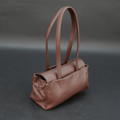 Brown cow Chelsea leather bag with straps, two compartments, and zipper pocket.