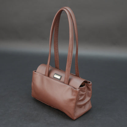 Brown cow Chelsea leather bag with straps, two compartments, and zipper pocket.