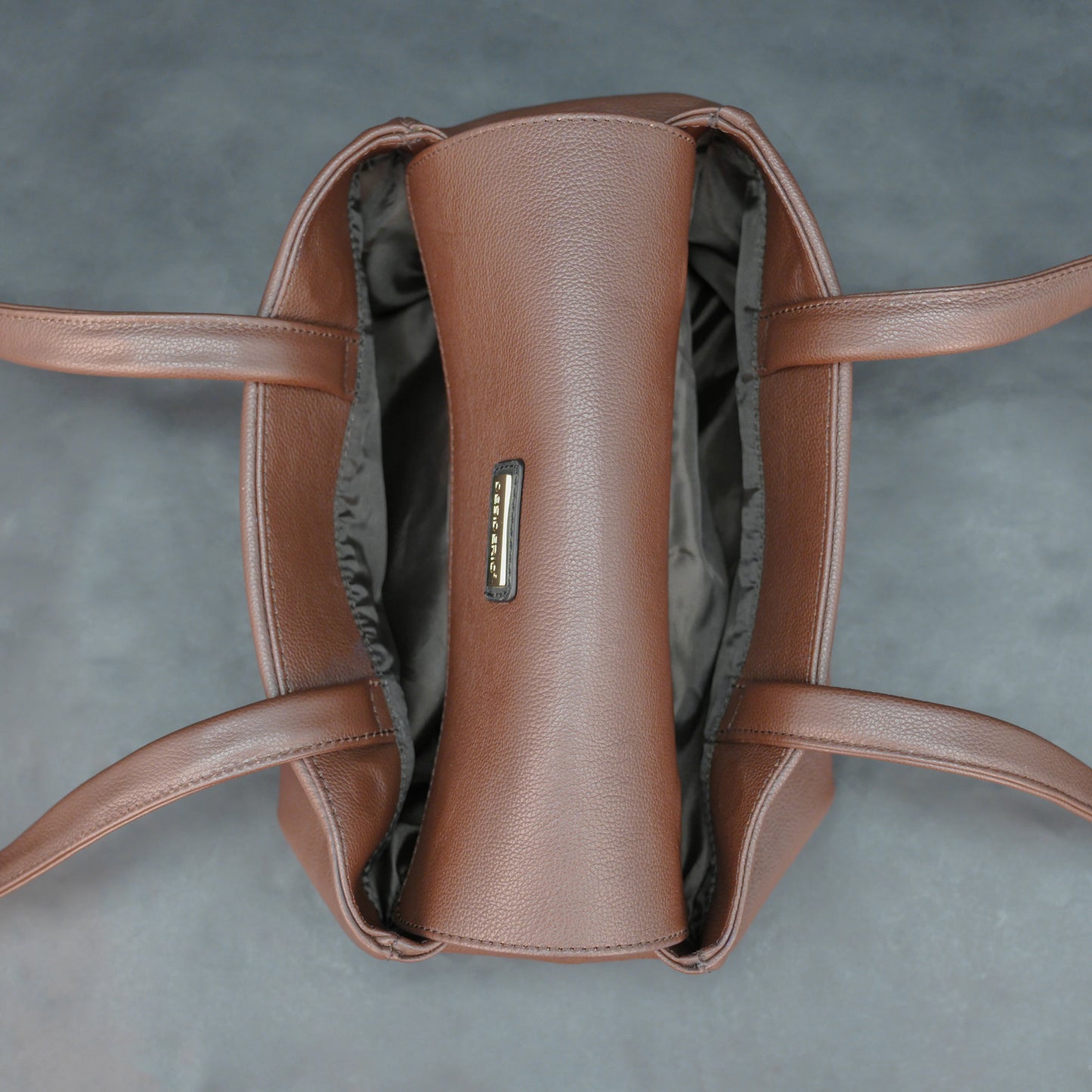 Brown cow Chelsea leather bag with straps, two compartments, and zipper pocket.