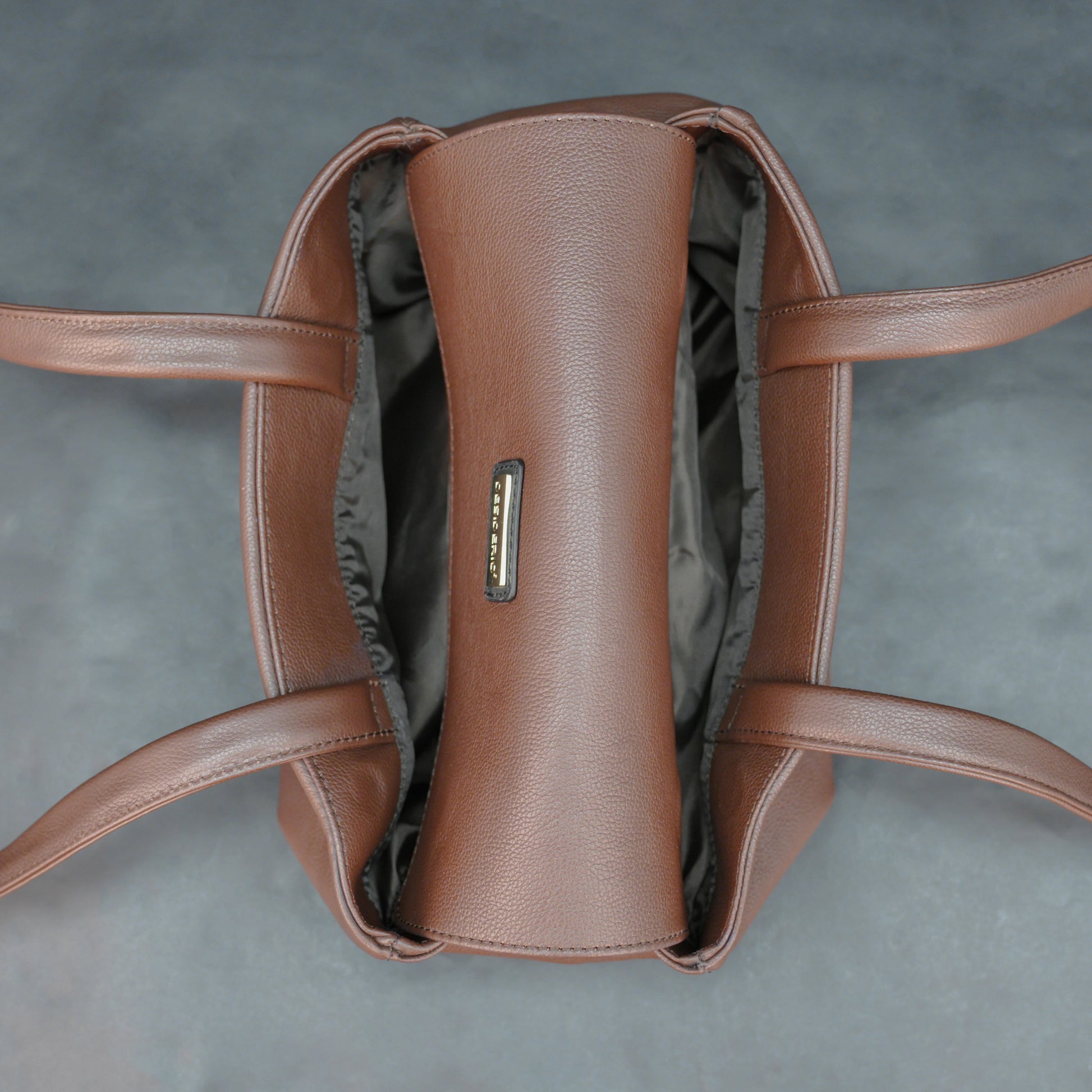 Brown cow Chelsea leather bag with straps, two compartments, and zipper pocket.