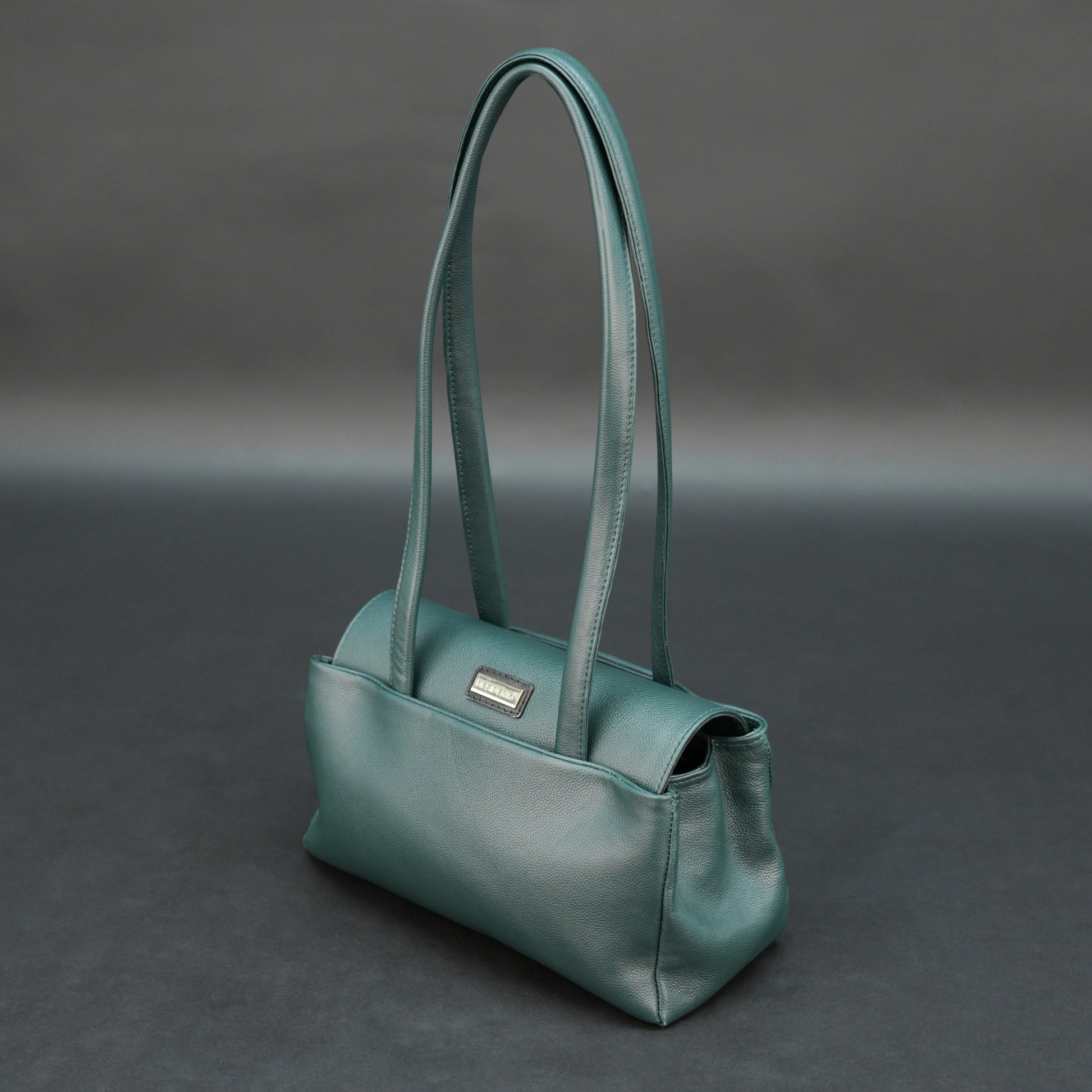 Deep jade cow Bamie leather bag with straps, dual compartments, and zipper pocket.