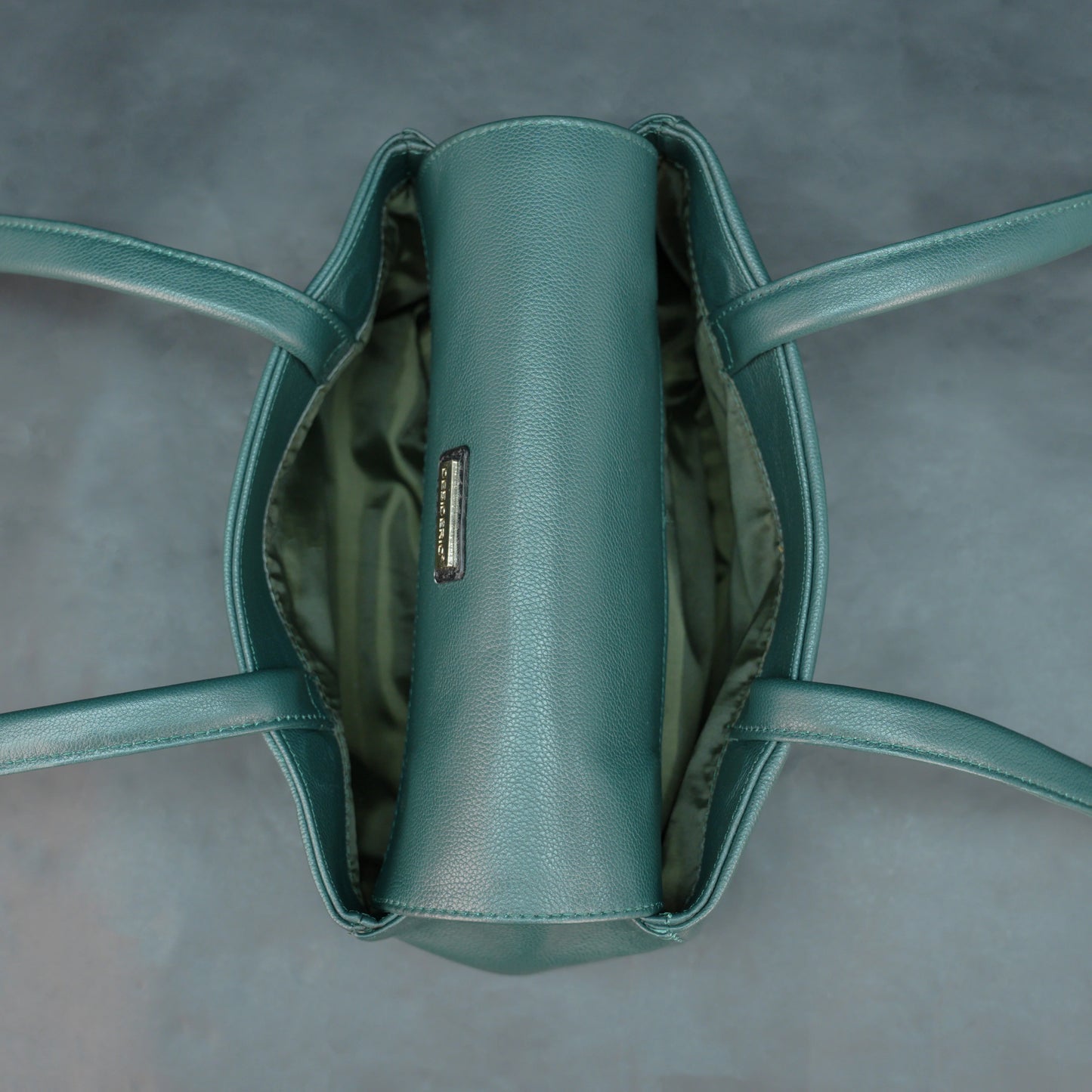 Deep jade cow Bamie leather bag with straps, dual compartments, and zipper pocket.