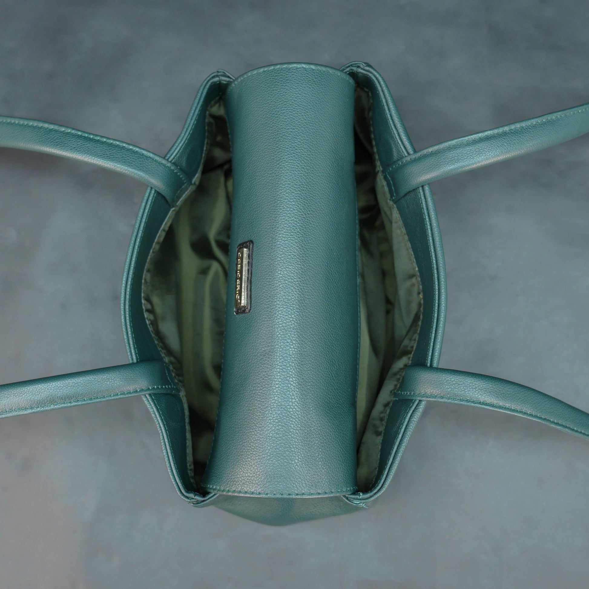 Deep jade cow Bamie leather bag with straps, dual compartments, and zipper pocket.