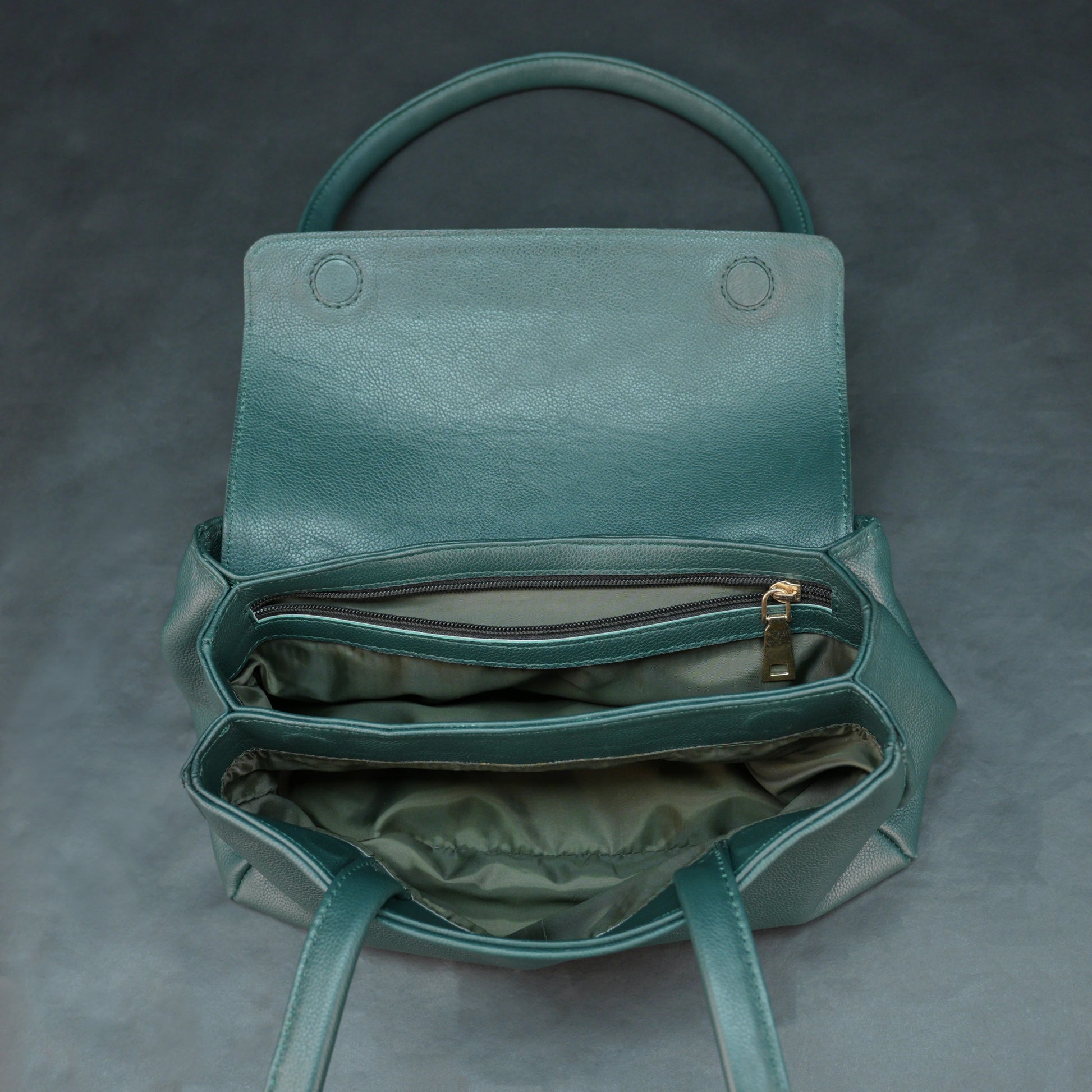 Deep jade cow Bamie leather bag with straps, dual compartments, and zipper pocket.