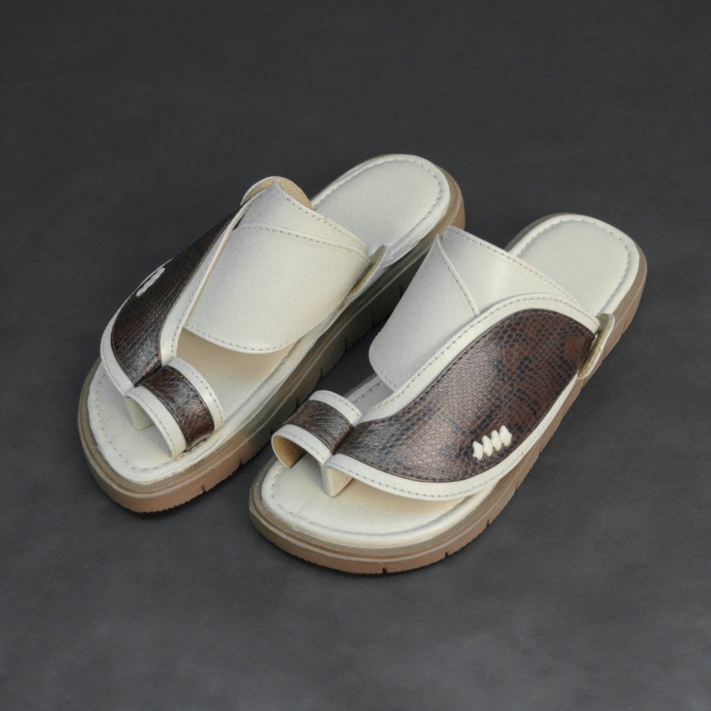 Off-white Arabic chappal with snake-pattern PU upper and EVA sole.