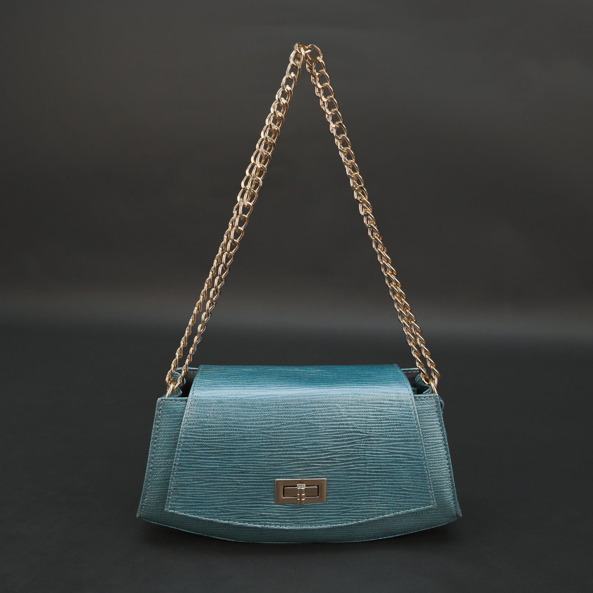 Aqua real leather handbag with brass chain and zipper compartment.