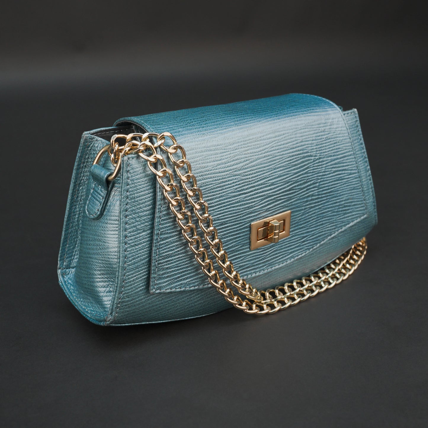 Aqua real leather handbag with brass chain and zipper compartment.