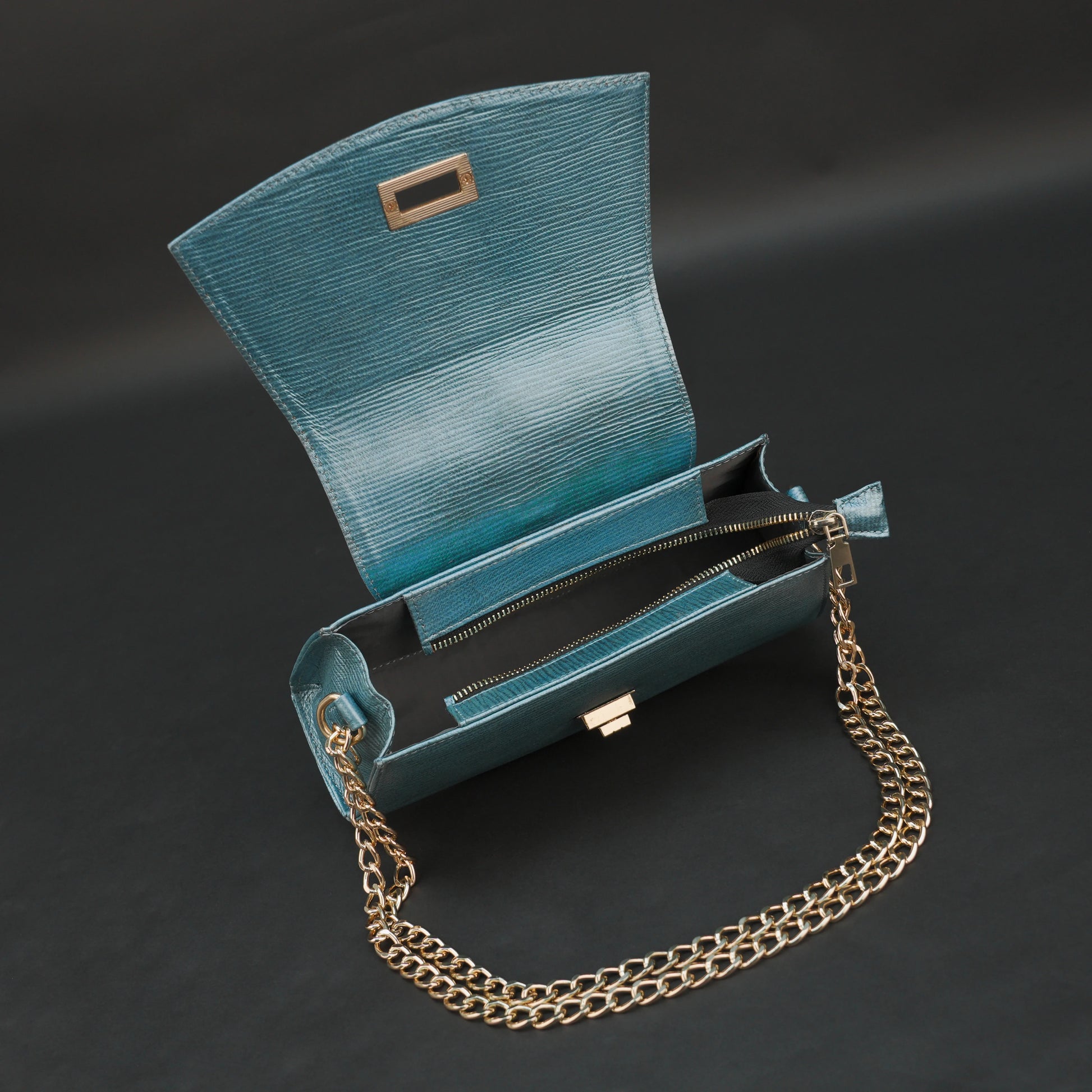 Aqua real leather handbag with brass chain and zipper compartment.