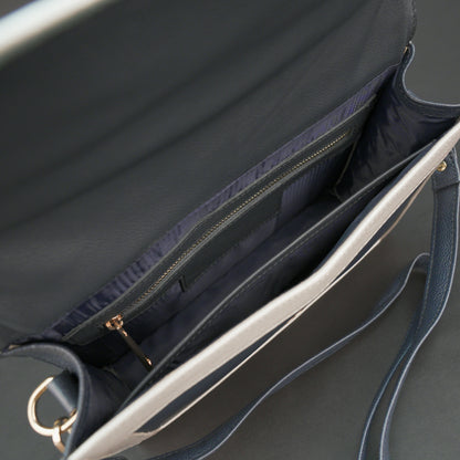 Dark blue leather crossbody handbag with zipper compartment and pocket.