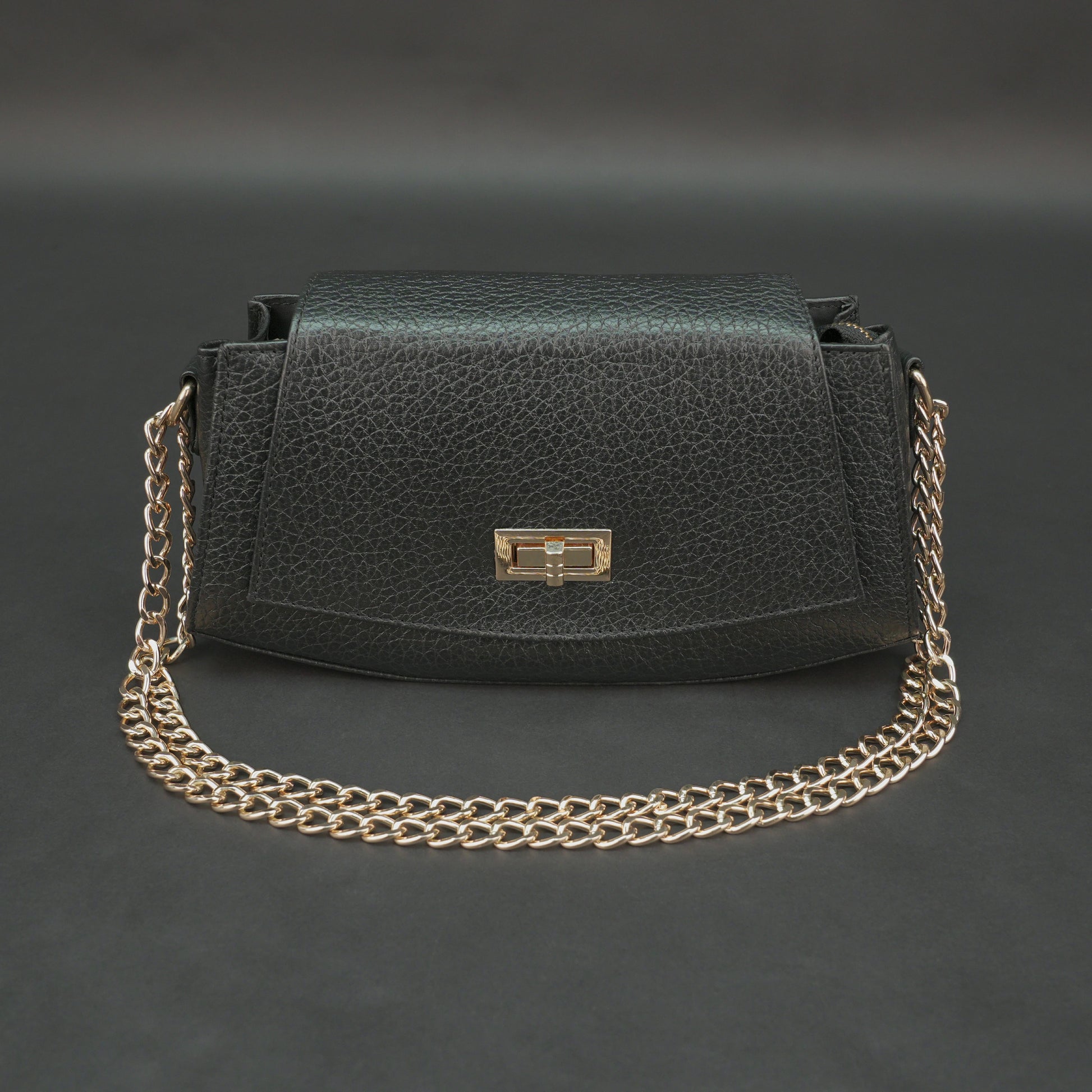 Black real leather handbag with brass chain and zip compartment.
