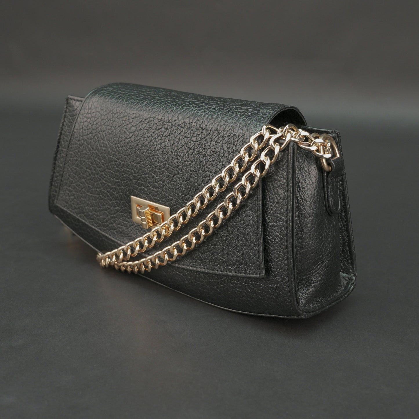 Black real leather handbag with brass chain and zip compartment.