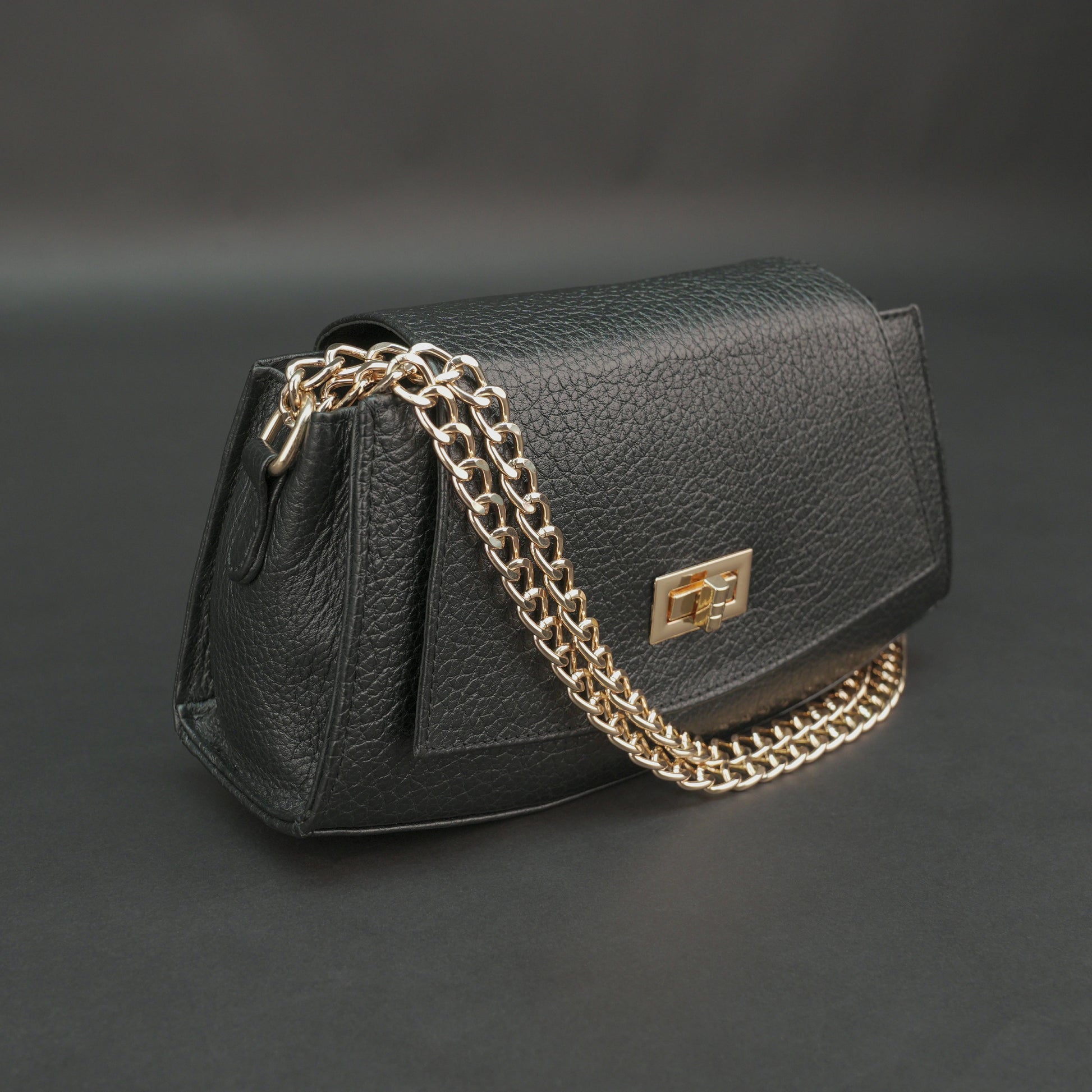Black real leather handbag with brass chain and zip compartment.