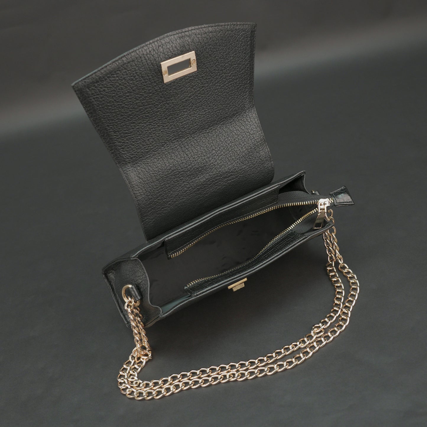 Black real leather handbag with brass chain and zip compartment.