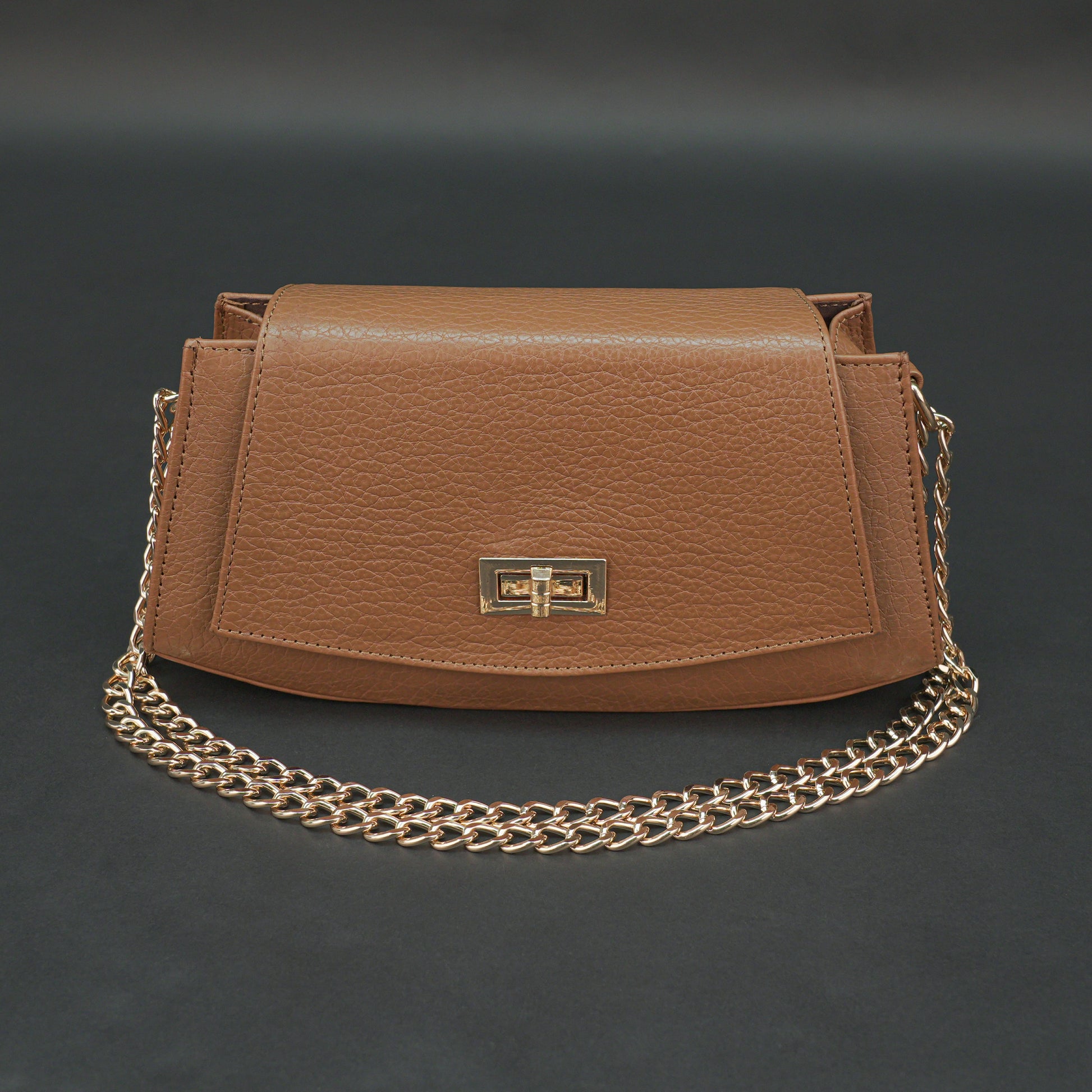 Tan leather handbag with chain and zipper.