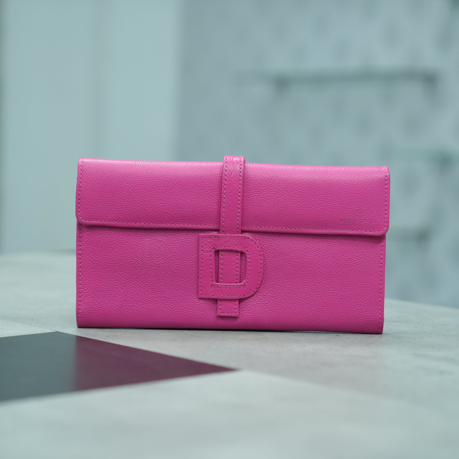 Stylish pink leather mini clutch with a compact and feminine design, including 3 organizing compartments, 16 card holders, and a secure zip pocket for coins or key