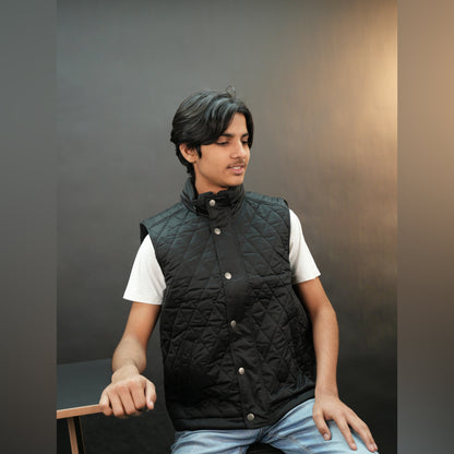 Black vest with a zip closure and snap button, two side pockets with snap buttons, and one inside pocket for secure storage