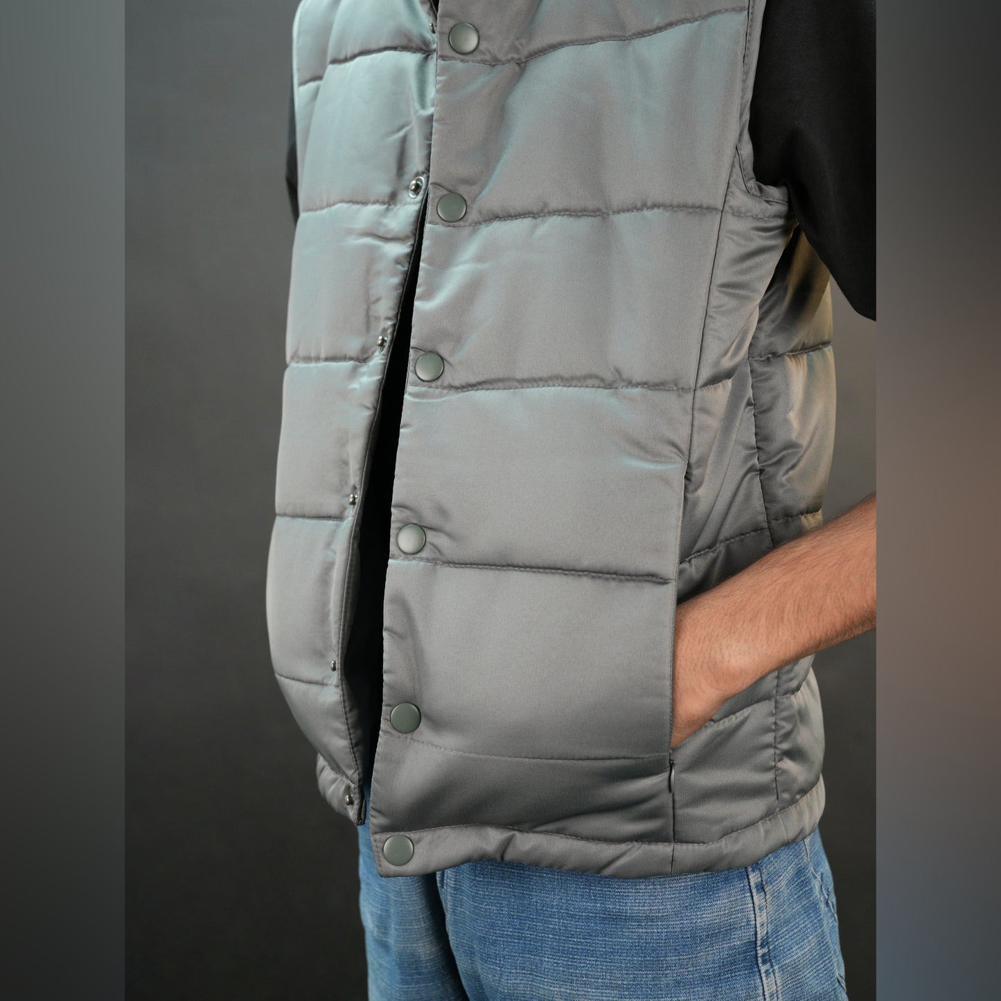 Grey jacket with a button closure, snap-button side pockets, and a single inner pocket for easy and secure storage