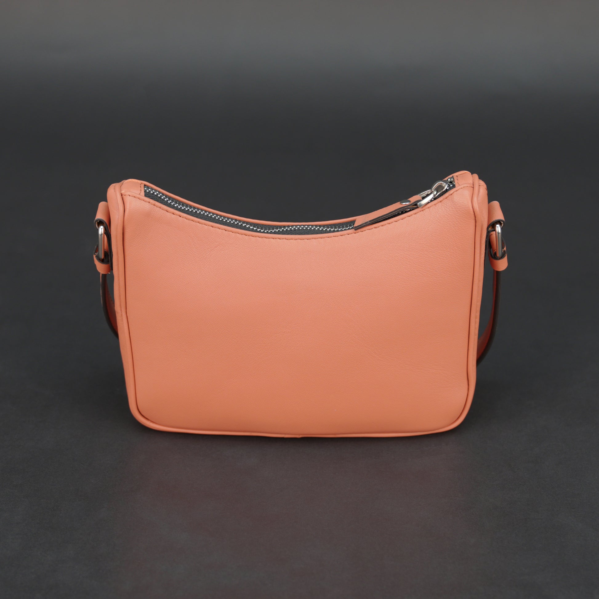 Coral sheep leather bag with zip closure and pockets.