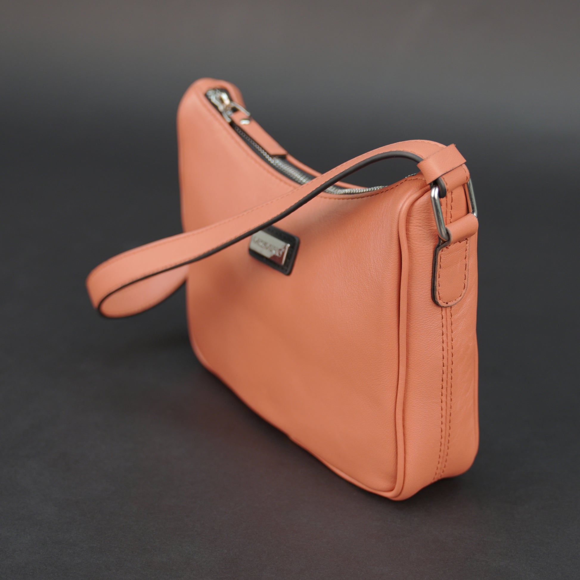 Coral sheep leather bag with zip closure and pockets.