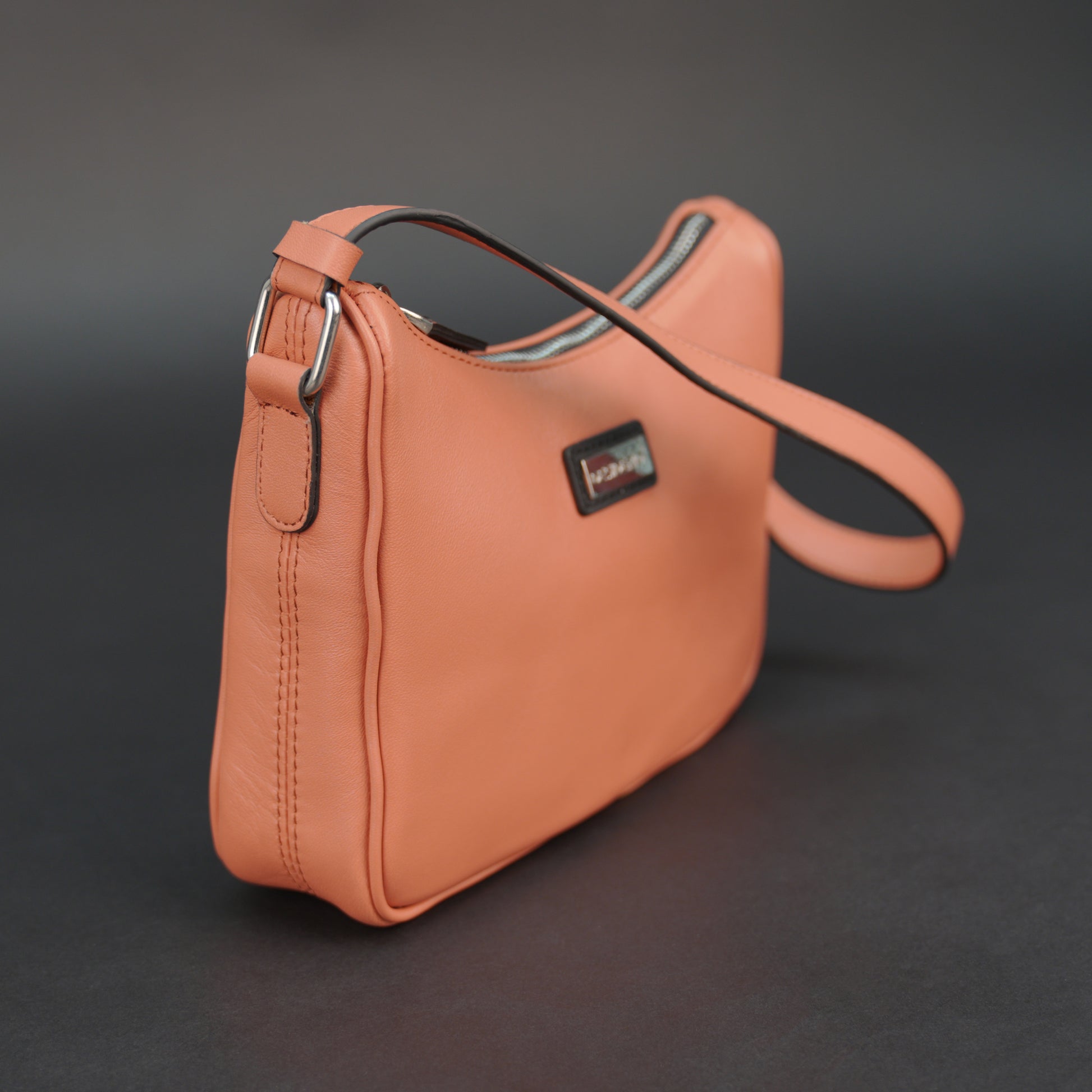 Coral sheep leather bag with zip closure and pockets.