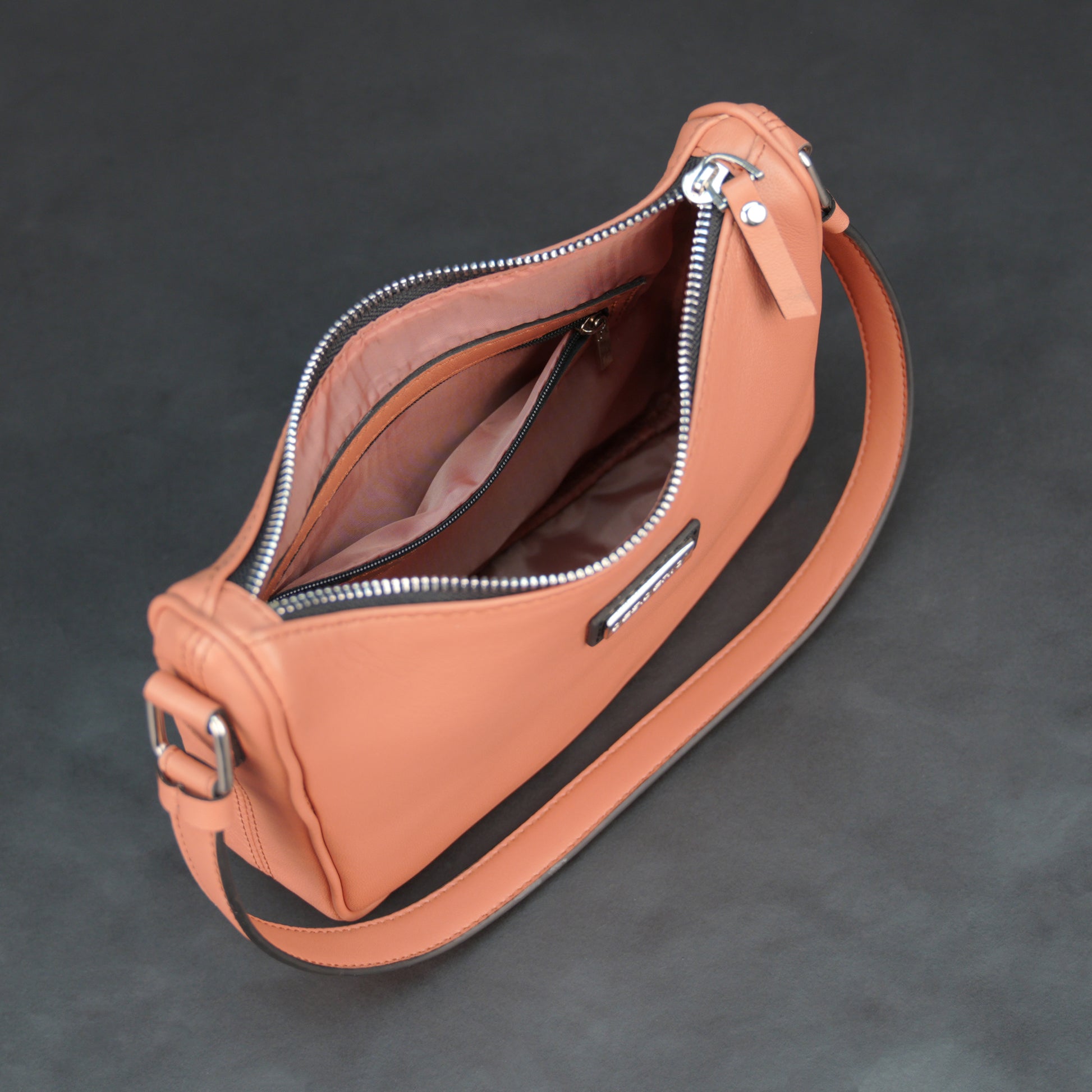 Coral sheep leather bag with zip closure and pockets.