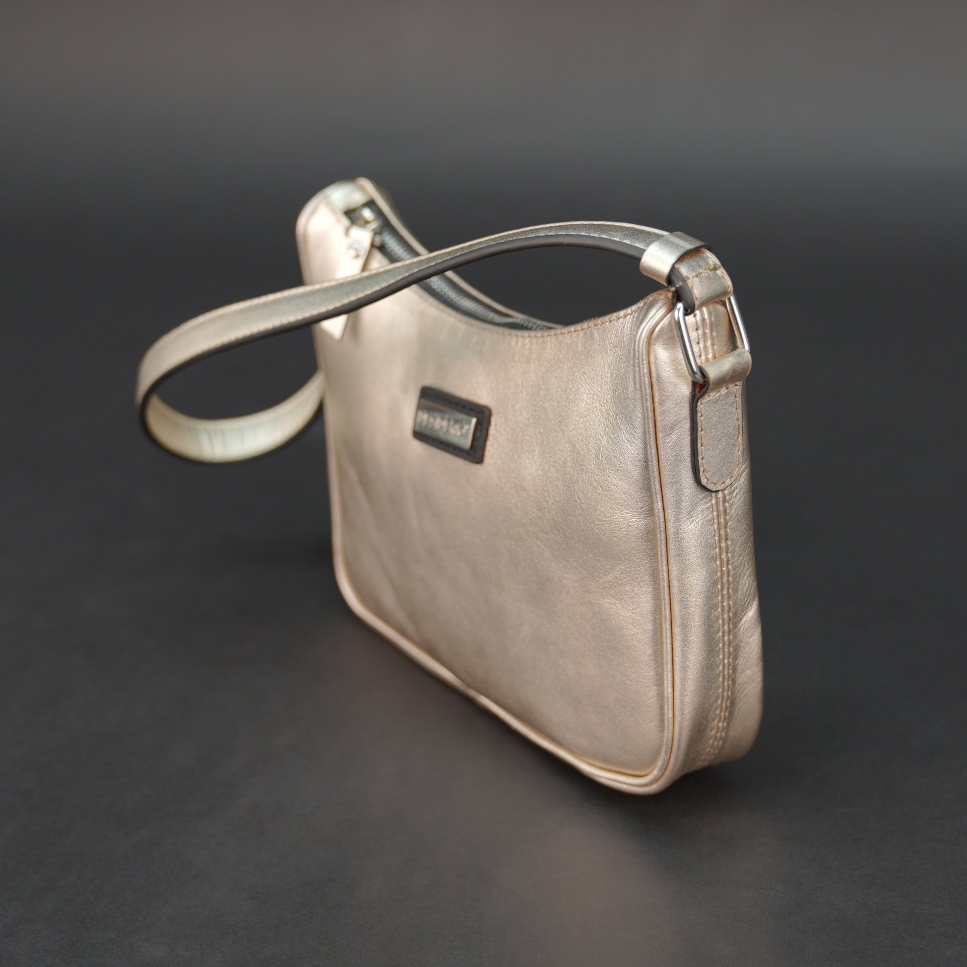 Metallic premium cow leather bag with zip closure, main compartment, and inner pocket for daily use.