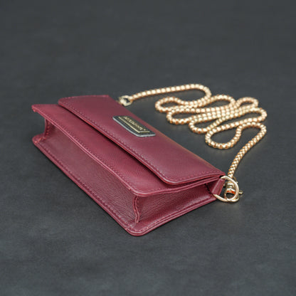 Burgundy goat leather bag with chain strap, main compartment, and inner pocket.