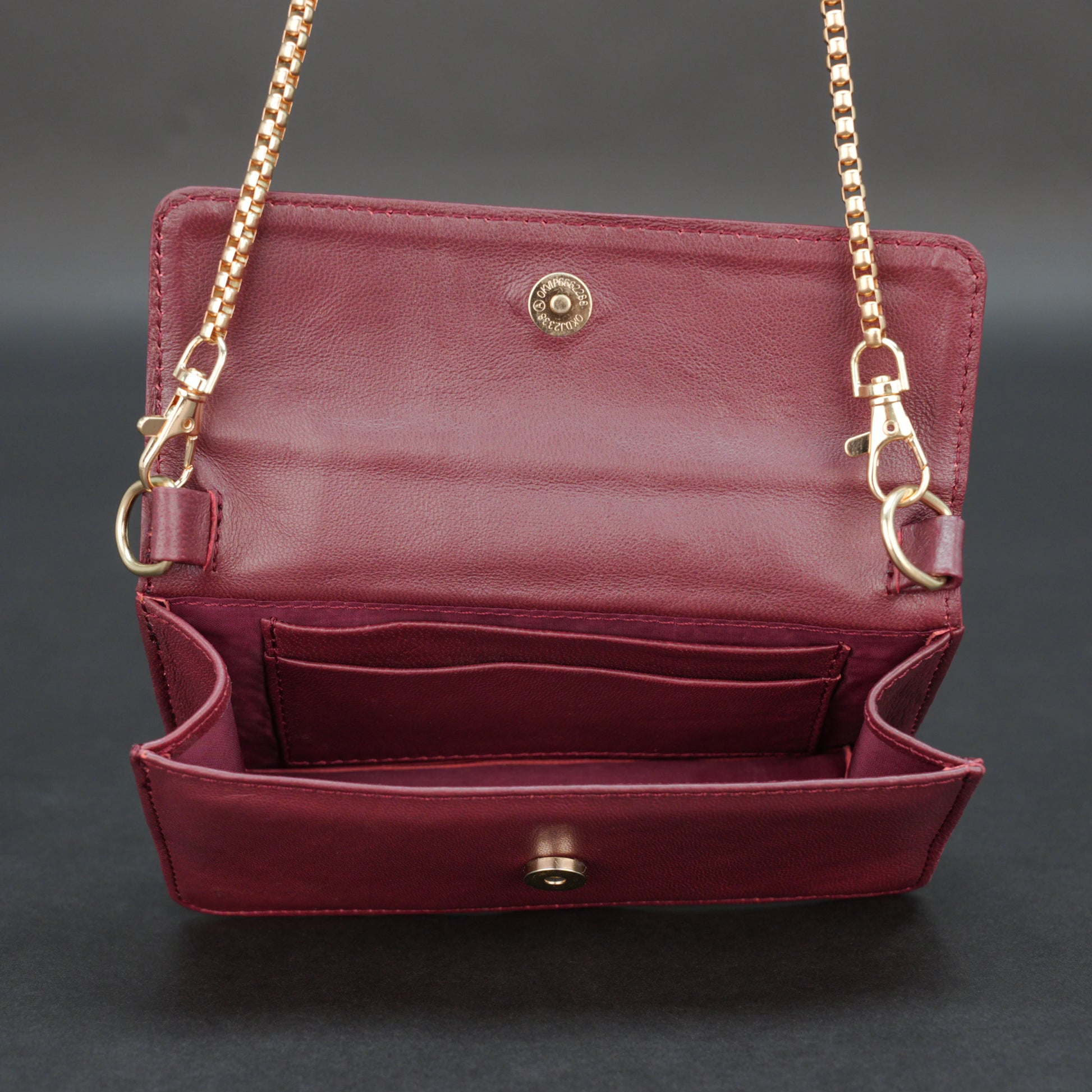Burgundy goat leather bag with chain strap, main compartment, and inner pocket.